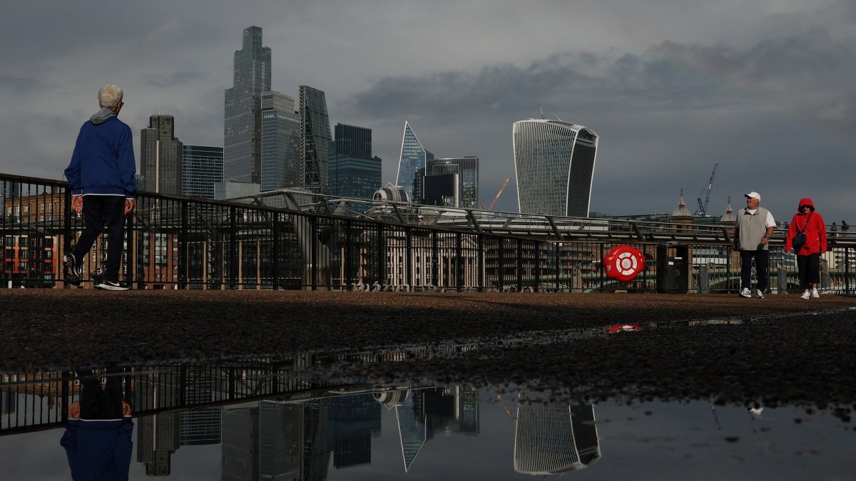 Skyscrapers of the City of London financial district are reflected in a puddle following heavy rain, in London, Britain, Sept. 8, 2026. (Reuters Photo)