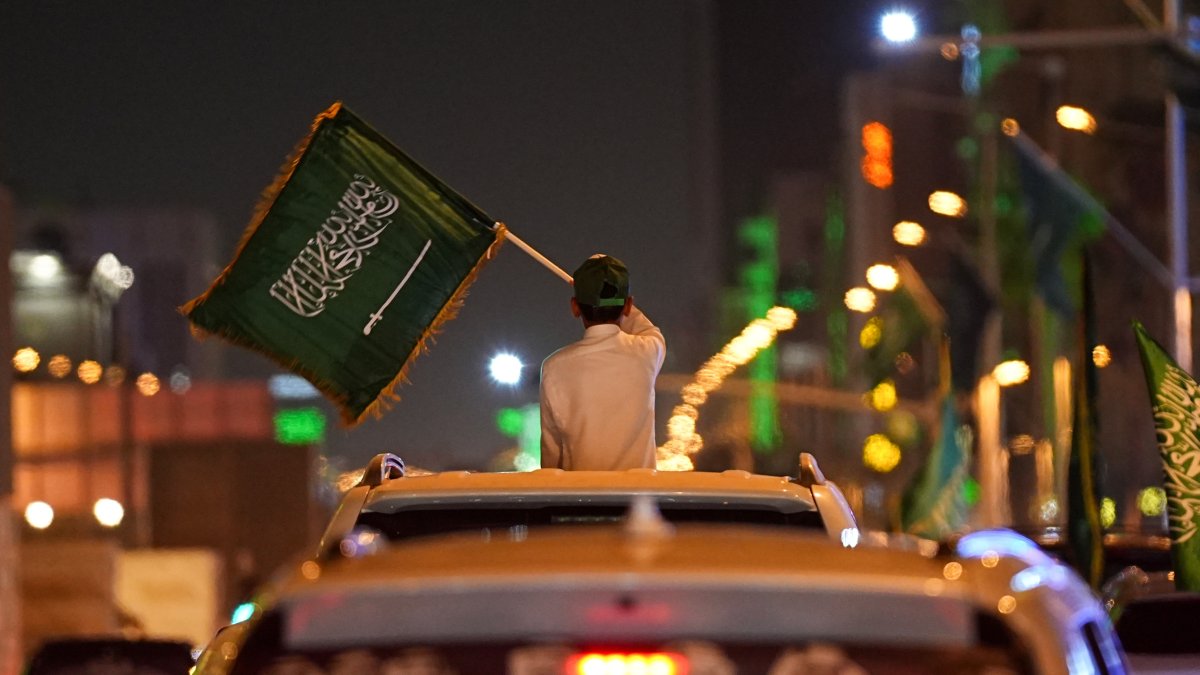 A child waves a Saudi flag from a car window during celebrations on Saudi Arabia's 96th National Day, in Riyadh, Saudi Arabia, Sept. 23, 2026.
