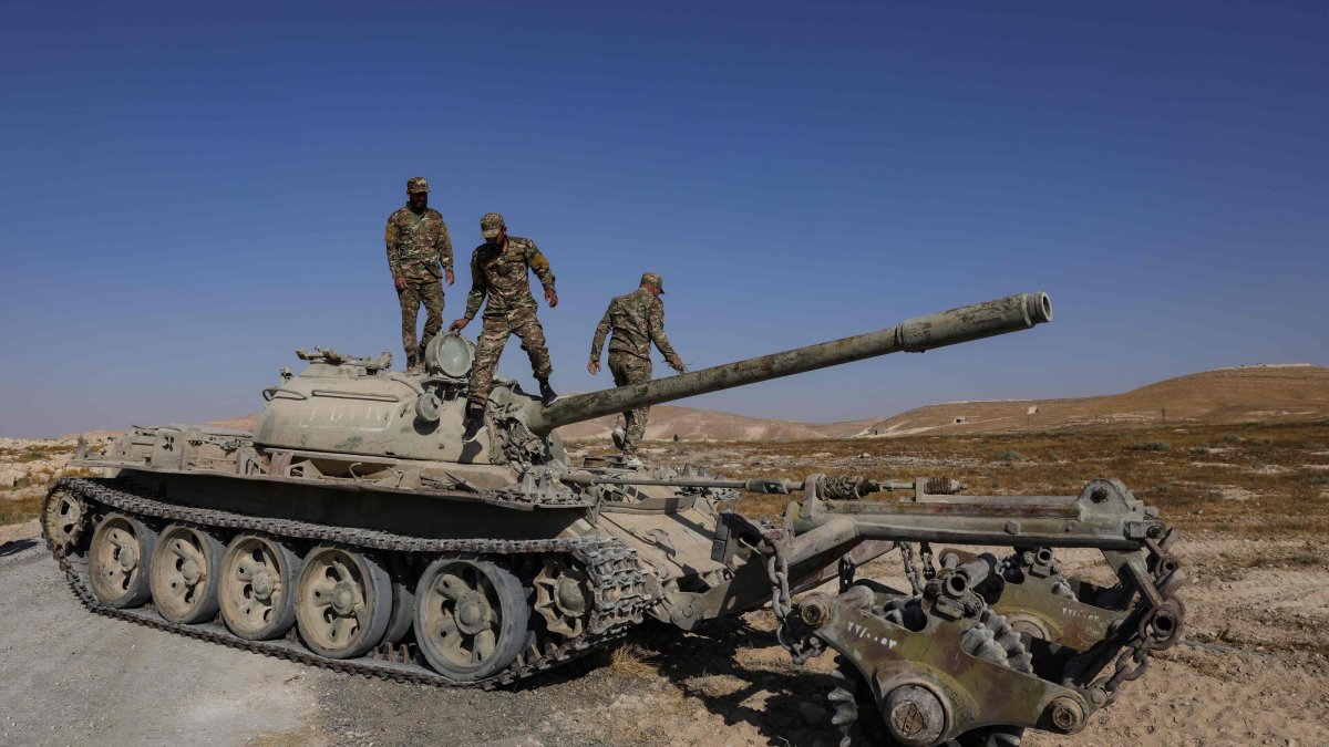 Syrian army soldiers stand on the chassis of a mine-clearing tank of the Syrian Ministry of Defence's military engineering department during a demining operation in Qarah in the Damascus countryside, Aug. 23, 2026. (AFP File Photo)