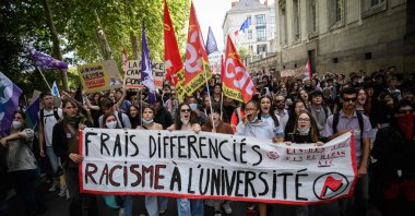 Protesters march with a banner that reads "Differing tuition rates, Racism in university" as they take part in a rally during a day of nationwide public sector strikes and demonstrations, Nantes, western France, Sept. 29, 2026. (AFP Photo)