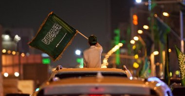 A child waves a Saudi flag from a car window during celebrations on Saudi Arabia's 96th National Day, in Riyadh, Saudi Arabia, Sept. 23, 2026.