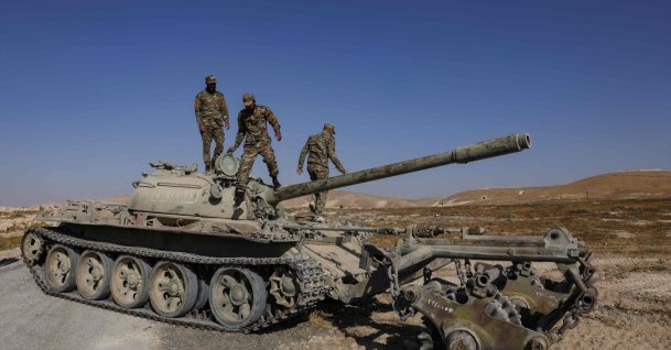 Syrian army soldiers stand on the chassis of a mine-clearing tank of the Syrian Ministry of Defence's military engineering department during a demining operation in Qarah in the Damascus countryside, Aug. 23, 2026. (AFP File Photo)
