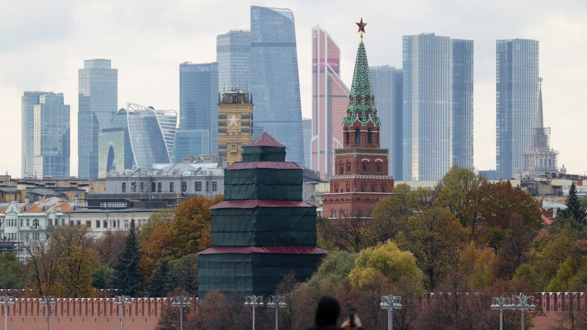 A pedestrian uses a mobile phone while standing on a bridge near the Kremlin wall, in Moscow, Russia, Oct. 23, 2025. (Reuters Photo)