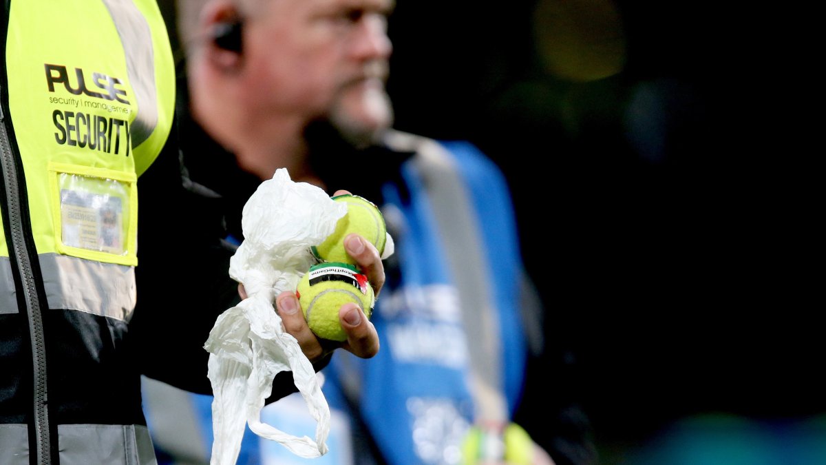 Stewards and security pick up tennis balls with the Palestinian flag stuck on them during the UEFA Nations League match between the Republic of Ireland and Austria, Dublin, Ireland, Oct. 1, 2026. (EPA Photo)