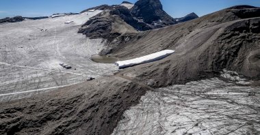 This aerial photograph shows the melting Tsanfleuron Glacier (L) and the melting Scex Rouge glacier (R) separated by the Tsanfleuron pass with synthetic blankets covering snow from the previous winter season to prevent it from melting, above Les Diablerets, western Switzerland, Sept. 6, 2026. (AFP Photo)