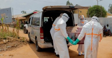 Members of the Civil Protection carry a wooden coffin before loading the body of an unidentified man who died of Ebola, Ituri Province, DRC, July 10, 2026. (Reuters Photo)
