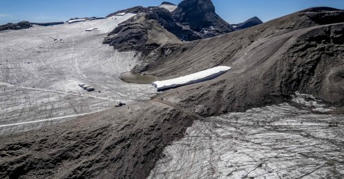 This aerial photograph shows the melting Tsanfleuron Glacier (L) and the melting Scex Rouge glacier (R) separated by the Tsanfleuron pass with synthetic blankets covering snow from the previous winter season to prevent it from melting, above Les Diablerets, western Switzerland, Sept. 6, 2026. (AFP Photo)