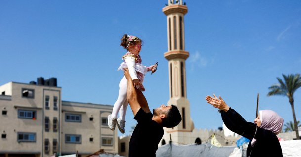 Maternal uncle of Bissan, who was evacuated as a premature baby during the two-year Israeli offensive for treatment in Egypt, plays with her after she returned to Gaza as her Palestinian mother Sundus al-Kurd, 29, reaches out her arms, Gaza Strip, Palestine, March 31, 2026. (Reuters Photo)