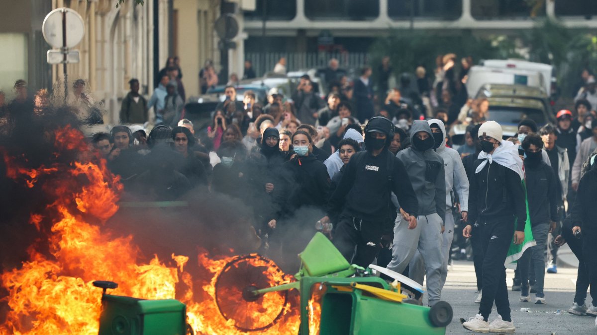 A student throws trash into a fire as protesting students carry out a blockade near Place de la Nation, Paris, France, Oct. 2, 2026. (AFP Photo)