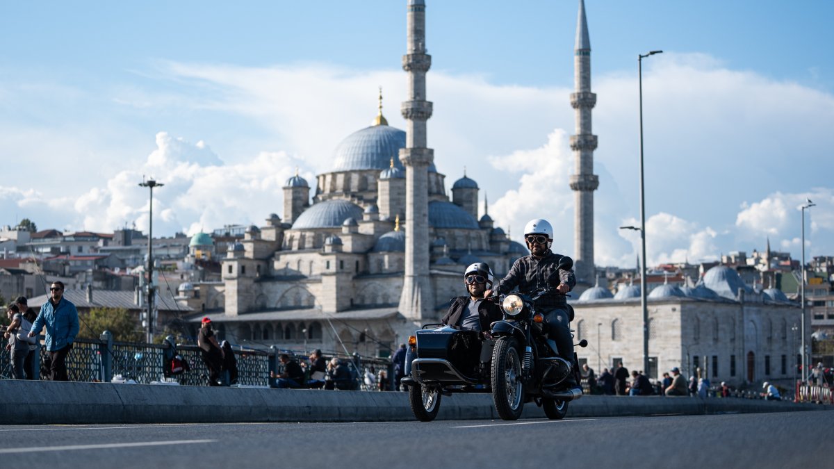 A man and a woman ride on a retro sidecar motorcycle in Eminönü with Yeni Camii in the background, Istanbul, Türkiye, Sept. 24, 2026. (AA Photo)