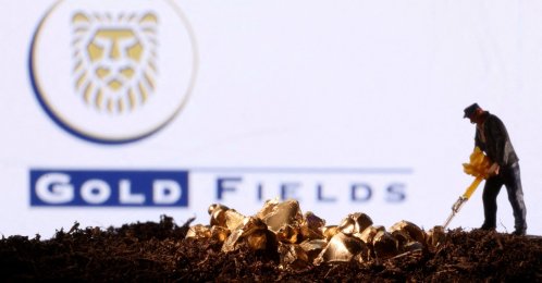 A small toy figure and gold imitation are seen in front of the Gold Fields logo in this illustration taken Nov. 19, 2021. (Reuters Photo)
