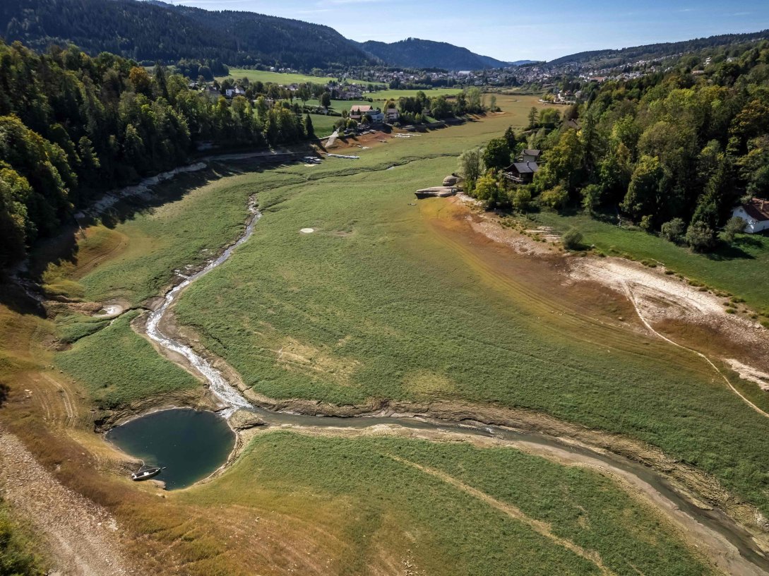 An aerial view of the bed of Lake Brenets, parched and now covered in grass, and a part of the Doubs River forming a natural border between eastern France and western Switzerland, Les Brenets, Switzerland, Sept. 25, 2026. (AFP Photo)