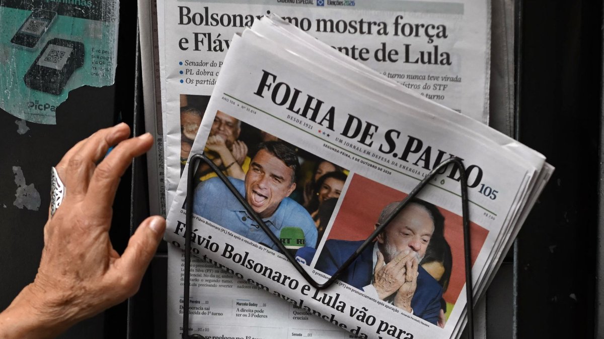 A person reaches for copies of the newspaper Folha de Sao Paulo displaying coverage of Brazil's presidential election results at a newsstand in Sao Paulo, Brazil, Oct. 5, 2026. (AFP Photo)