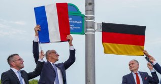 German Chancellor Friedrich Merz (C), Marc Speicher (L), Mayor of Saarlouis, and Jerome Spinoza (R), Consul General of France in Saarland, unveil the streets in honor of the late former German chancellor Helmut Kohl and the late former French president Francois Mitterrand, in Saarlouis, Germany, Sept. 28 2026. (AFP Photo)