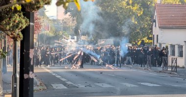 A protester launches a firework during clashes with the police in the streets near Paris, in Sartrouville, France, Oct. 5, 2026. (Reuters Photo)