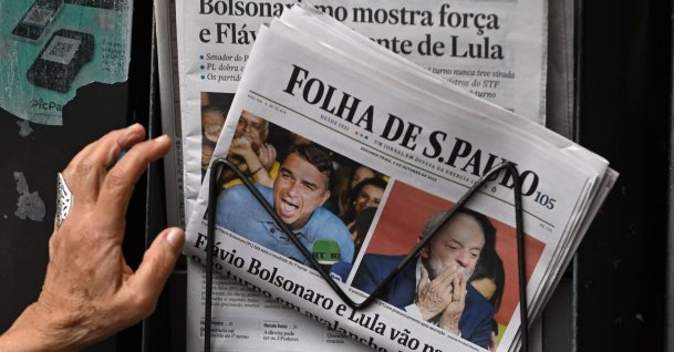 A person reaches for copies of the newspaper Folha de Sao Paulo displaying coverage of Brazil's presidential election results at a newsstand in Sao Paulo, Brazil, Oct. 5, 2026. (AFP Photo)