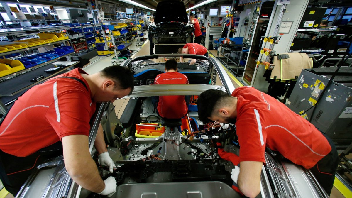 Employees of German car manufacturer Porsche work on a Porsche 911 at the Porsche factory, Stuttgart-Zuffenhausen, Germany, Feb. 19, 2019. (Reuters Photo)