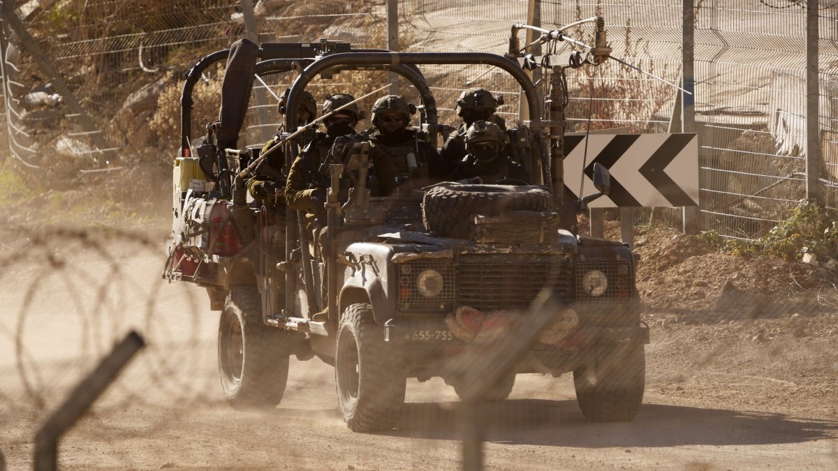 Israeli soldiers drive an armored vehicle along the security fence near the Alpha Line that separates the Israeli-occupied Golan Heights, Majdal Shams, Syria, Dec. 19, 2024. (AP Photo)