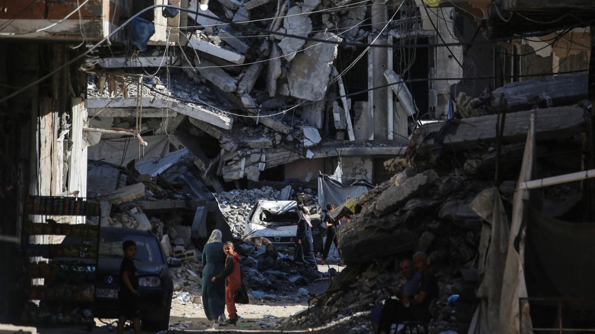 People walk along a street lined with buildings destroyed in Israeli attacks at the Jabalia refugee camp in the northern Gaza Strip, Palestine, Oct. 5, 2026. (AFP Photo)