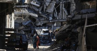 People walk along a street lined with buildings destroyed in Israeli attacks at the Jabalia refugee camp in the northern Gaza Strip, Palestine, Oct. 5, 2026. (AFP Photo)