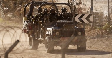 Israeli soldiers drive an armored vehicle along the security fence near the Alpha Line that separates the Israeli-occupied Golan Heights, Majdal Shams, Syria, Dec. 19, 2024. (AP Photo)