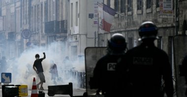 Police officers stand after firing a tear gas canister to disperse remaining protesters at the end of a demonstration, part of a nationwide day of actions called by high-school students, joined by unions and teachers, in Bordeaux, France, Oct. 6, 2026. (AFP Photo)