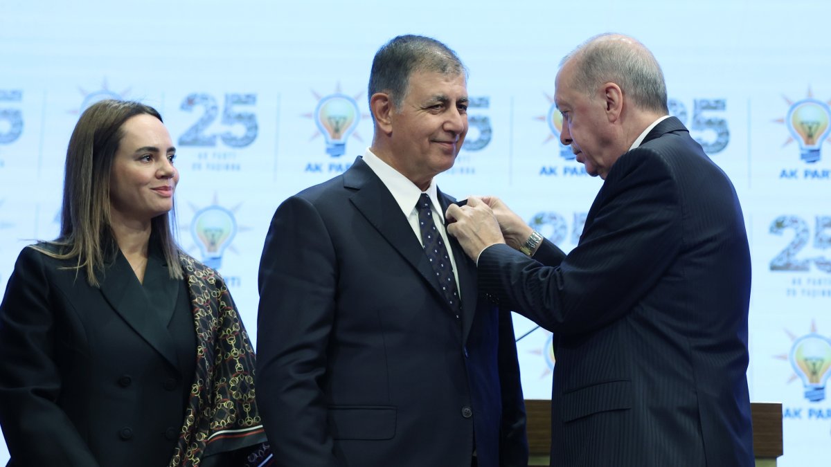 President Erdoğan presents a party badge to Cemil Tugay as the mayor's wife, Öznur Tugay, looks on, Ankara, Türkiye, Oct. 7, 2026. (AA Photo)