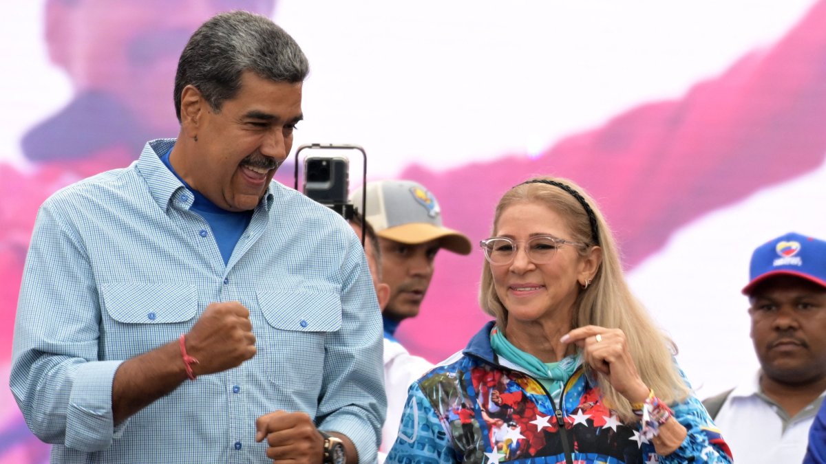 Venezuelan President and presidential candidate Nicolas Maduro dances next to his wife, Cilia Flores, at his campaign closing rally in Caracas, July 25, 2024. (AFP File Photo)