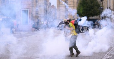Protestors stand amid tear gas fired by police during demonstration part of a nationwide day of actions called by high-school students, Bordeaux, southwestern France, Oct. 6, 2026. (AFP Photo)