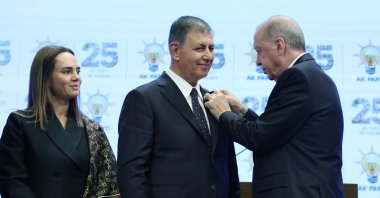 President Erdoğan presents a party badge to Cemil Tugay as the mayor's wife, Öznur Tugay, looks on, Ankara, Türkiye, Oct. 7, 2026. (AA Photo)