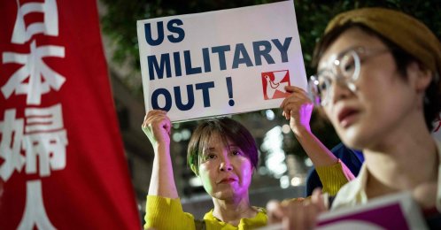 A woman holds up a placard reading 'US military out' during a protest against the killing of a woman in Okinawa allegedly committed by a U.S. Marine Corps member, Tokyo, Japan, October 5, 2026. (AFP Photo)