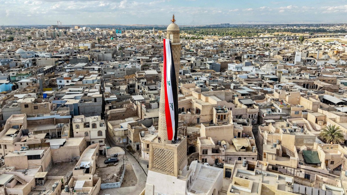A giant Iraqi flag hangs off the reconstructed 12th-century "Hadba" leaning minaret at the historic Great Mosque of al-Nuri, Mosul, Iraq, Sept. 29, 2026. (AFP Photo)