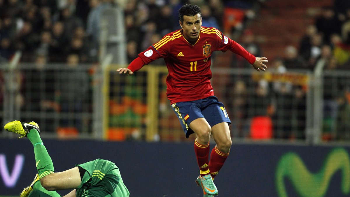Spain's Pedro Rodriguez (R) scores past  Belarus' Sergei Veremko during a World Cup 2014 Group qualification match, Minsk, Belarus, Oct. 12, 2012. (AP Photo)