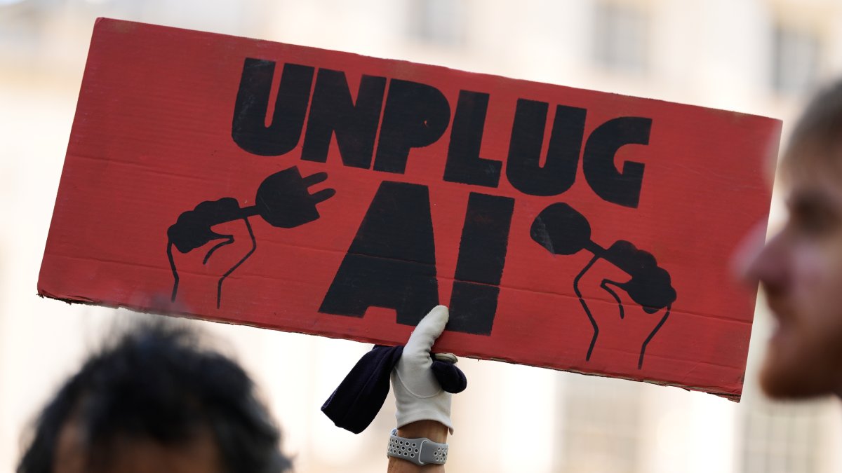 A small group of people supporting restrictions on artificial intelligence hold up signs in front of City Hall before a New York City Council hearing on artificial intelligence safety, New York, U.S., Oct. 5, 2026. (AP Photo)