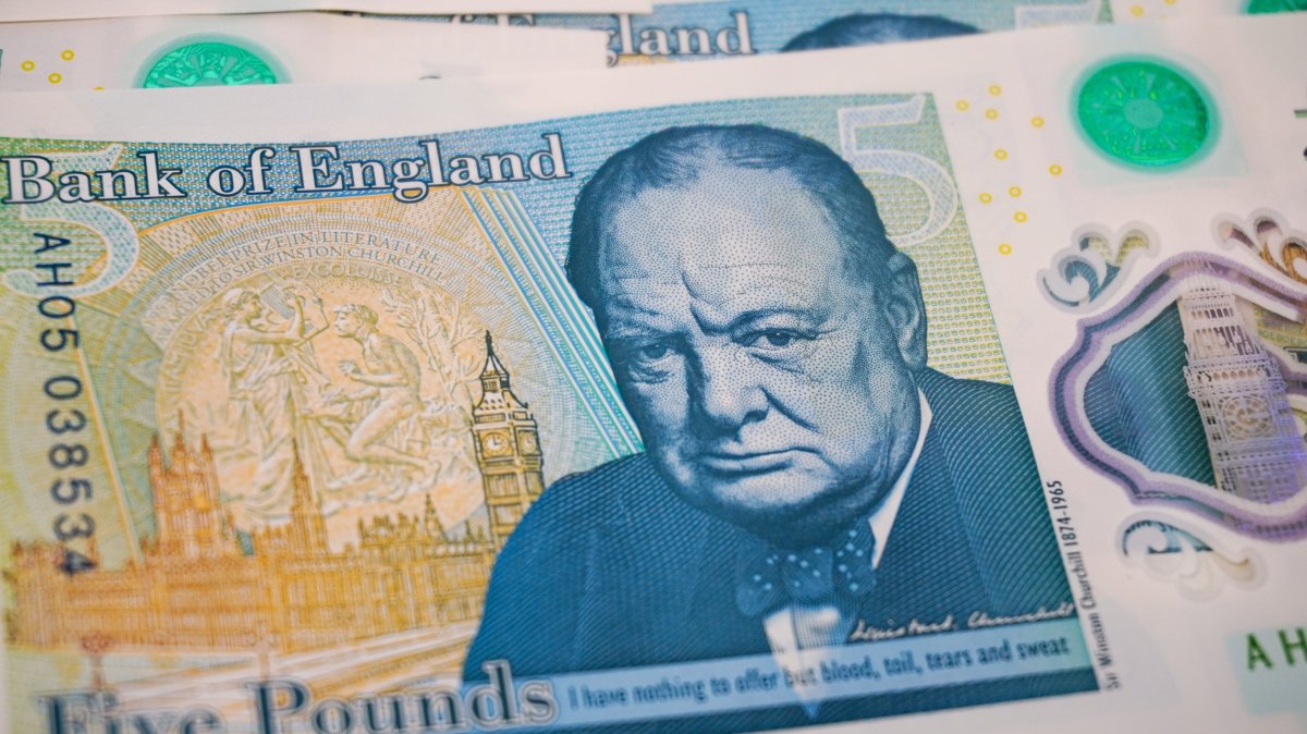 A detailed close-up of a British £5 polymer banknote, highlighting Winston Churchill's portrait and the quote "I have nothing to offer but blood, toil, tears and sweat," March 29, 2026. (Getty Images Photo)