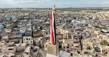 A giant Iraqi flag hangs off the reconstructed 12th-century "Hadba" leaning minaret at the historic Great Mosque of al-Nuri, Mosul, Iraq, Sept. 29, 2026. (AFP Photo)