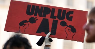 A small group of people supporting restrictions on artificial intelligence hold up signs in front of City Hall before a New York City Council hearing on artificial intelligence safety, New York, U.S., Oct. 5, 2026. (AP Photo)