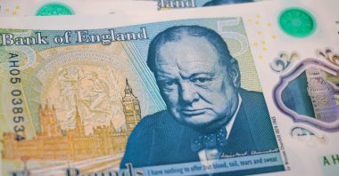 A detailed close-up of a British £5 polymer banknote, highlighting Winston Churchill's portrait and the quote "I have nothing to offer but blood, toil, tears and sweat," March 29, 2026. (Getty Images Photo)