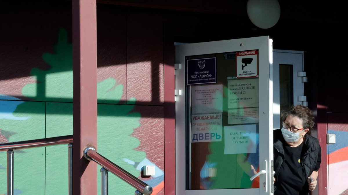 A security person wearing a face mask looks out from the door of an infectious diseases hospital in the town of Shelekhov, where an employee of the Irkutsk Antiplague Research Institute had died, Irkutsk region, Russia, Oct. 7, 2026. (AFP Photo)