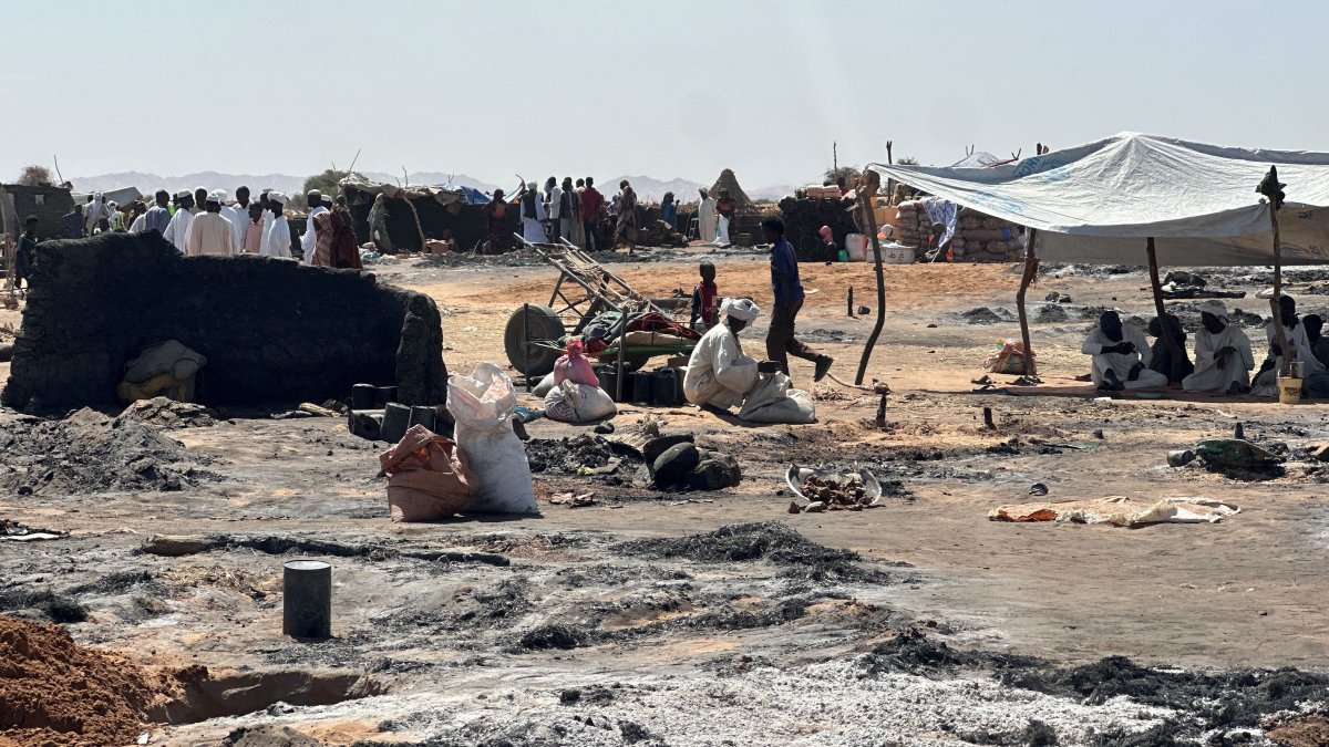 Displaced Sudanese people who left El-Fasher after its fall sit in the shade in Tawila amid the remains of a fire that broke out in the camp on Feb. 11, 2026. (AFP File Photo)