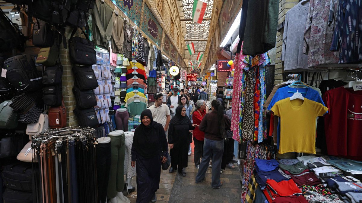 Shoppers walking through the Tajrish Bazaar. The marketplace in the Iranian capital's north would usually be abuzz with customers, but shops now sit mostly empty, with only small numbers of people walking its old, narrow paths, a jarring shift from the sellers shouting to promote their goods, Tehran, Iran, Oct. 7, 2026. (AFP Photo)