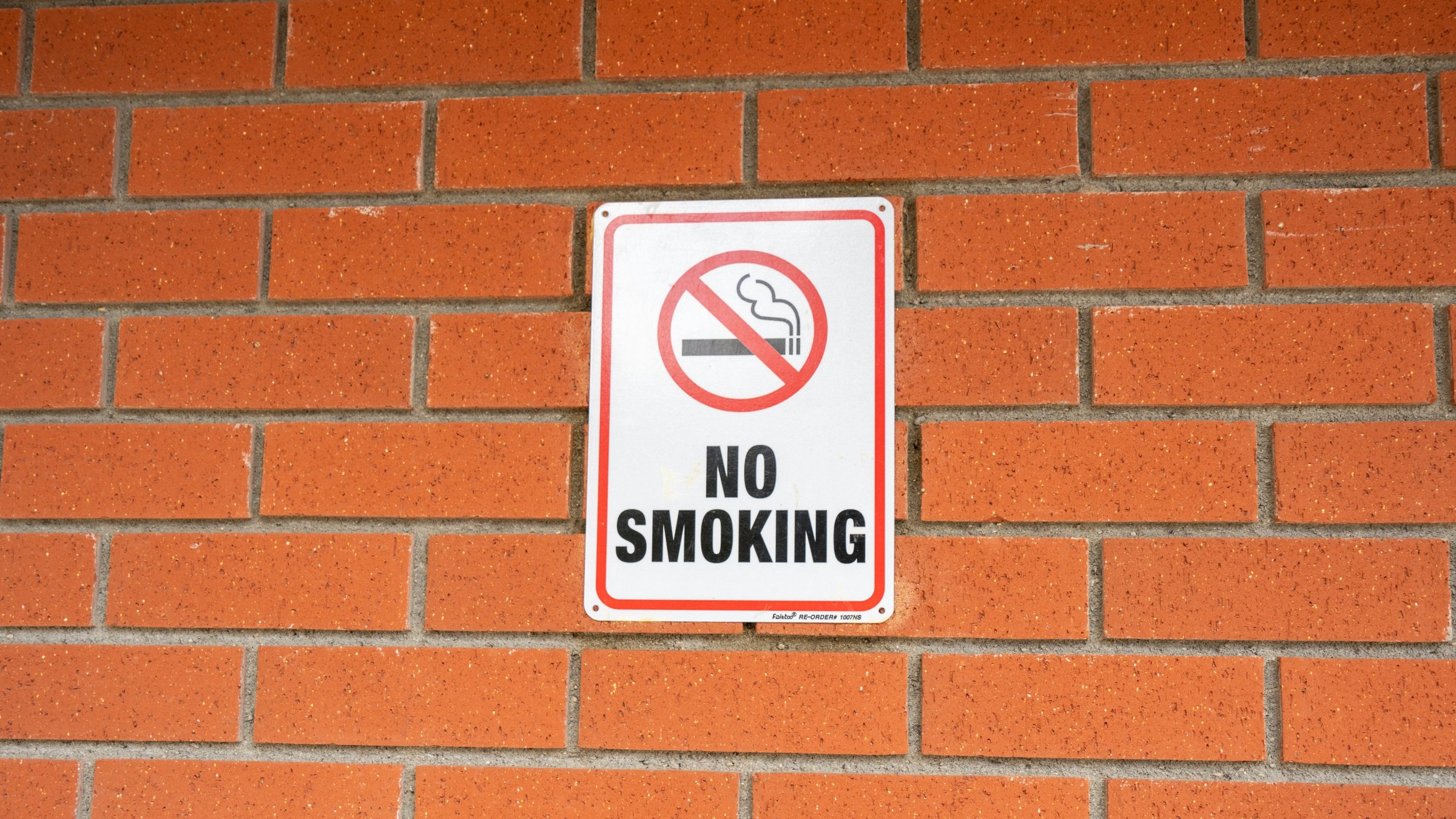 A no-smoking sign is on a wall of a building. (Shutterstock Photo)