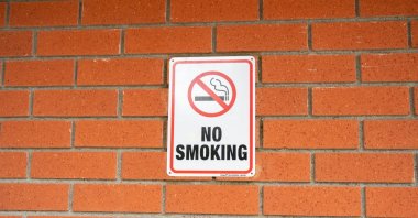 A no-smoking sign is on a wall of a building. (Shutterstock Photo)