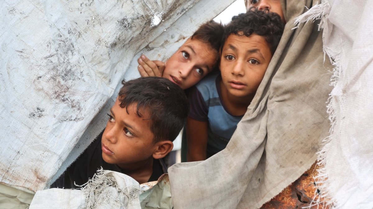 Palestinian children peek through a tent cover at the site of an Israeli strike on a tent in Khan Younis, southern Gaza Strip, Oct. 12, 2026. (Reuters Photo)