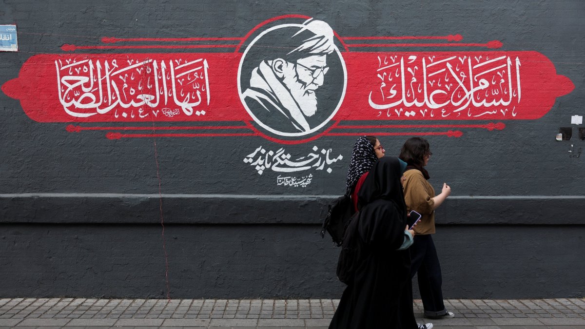 People walks past a mural depicting Iran's late Supreme Leader Ayatollah Ali Khamenei, in Tehran, Iran, Oct. 7, 2026. (Reuters Photo)