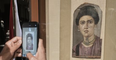 A visitor photographs one of the Fayoum portraits, "Demos," from the Greco-Roman period, at the Egyptian Museum, Cairo, Egypt, Oct. 11, 2026. (AP Photo)