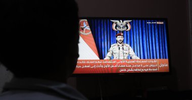 A person watches Houthi military spokesperson Yahya Sarea delivering a televised statement in Sanaa, Yemen, Oct. 11, 2026. (EPA Photo)