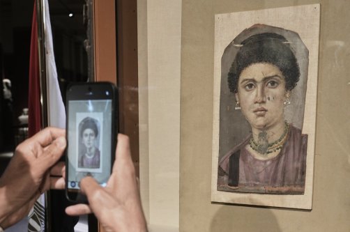 A visitor photographs one of the Fayoum portraits, "Demos," from the Greco-Roman period, at the Egyptian Museum, Cairo, Egypt, Oct. 11, 2026. (AP Photo)