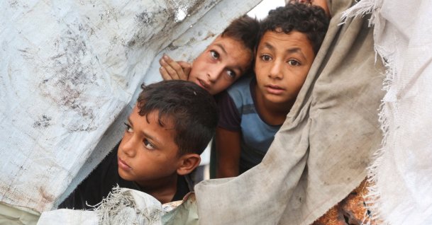Palestinian children peek through a tent cover at the site of an Israeli strike on a tent in Khan Younis, southern Gaza Strip, Oct. 12, 2026. (Reuters Photo)
