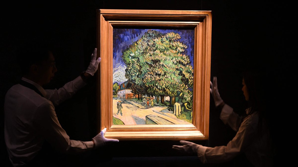 Sotheby's staff handle the "Chataigniers en fleurs" ("Chestnut Trees in Blossom") painting by Vincent Van Gogh at an auction preview, Hong Kong, China, Oct. 13, 2026. (AFP Photo)